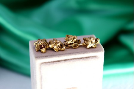 Botões de punho em ouro com relevos e figuras de leões profusamente definidas.